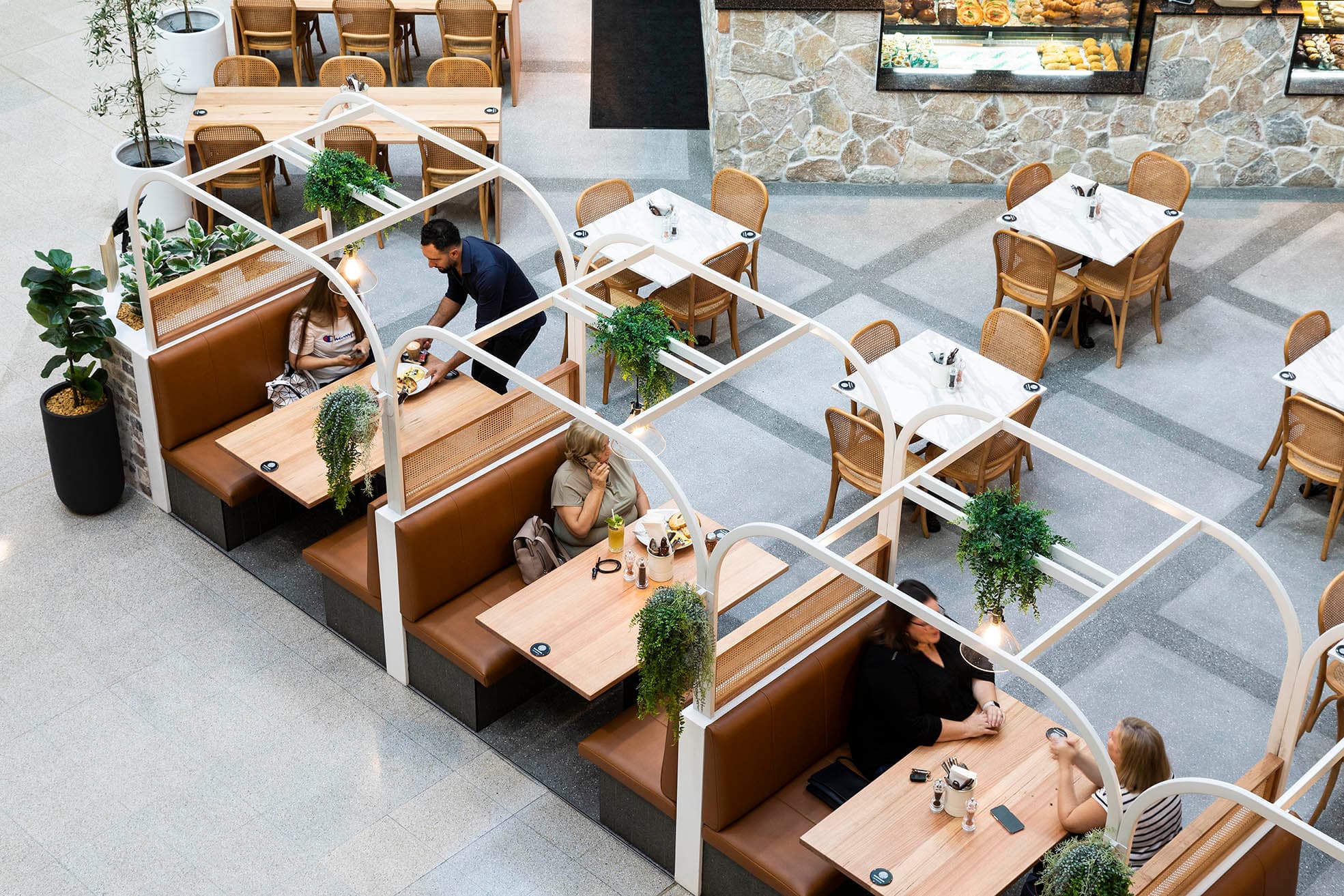 Aerial view of booth seating at Frankie B's Brunch House with patrons and server.