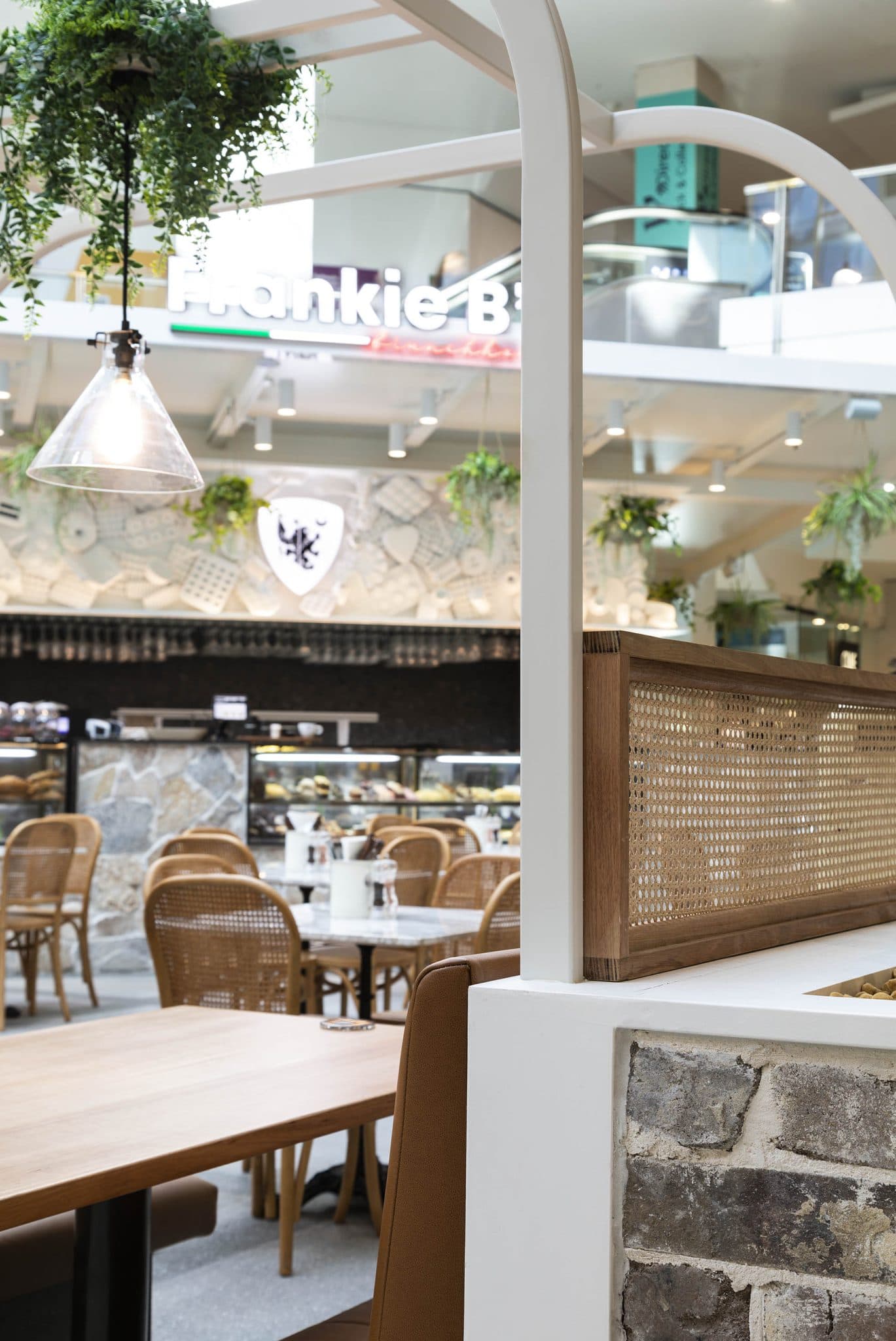 Close-up view of seating area with a modern lamp and Frankie B's Brunch House in the background.