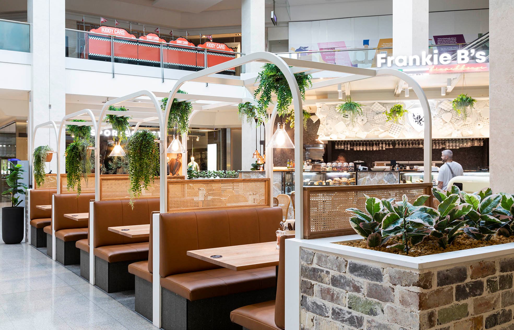 Frankie B's Brunch House seating area with green plants and comfortable booths