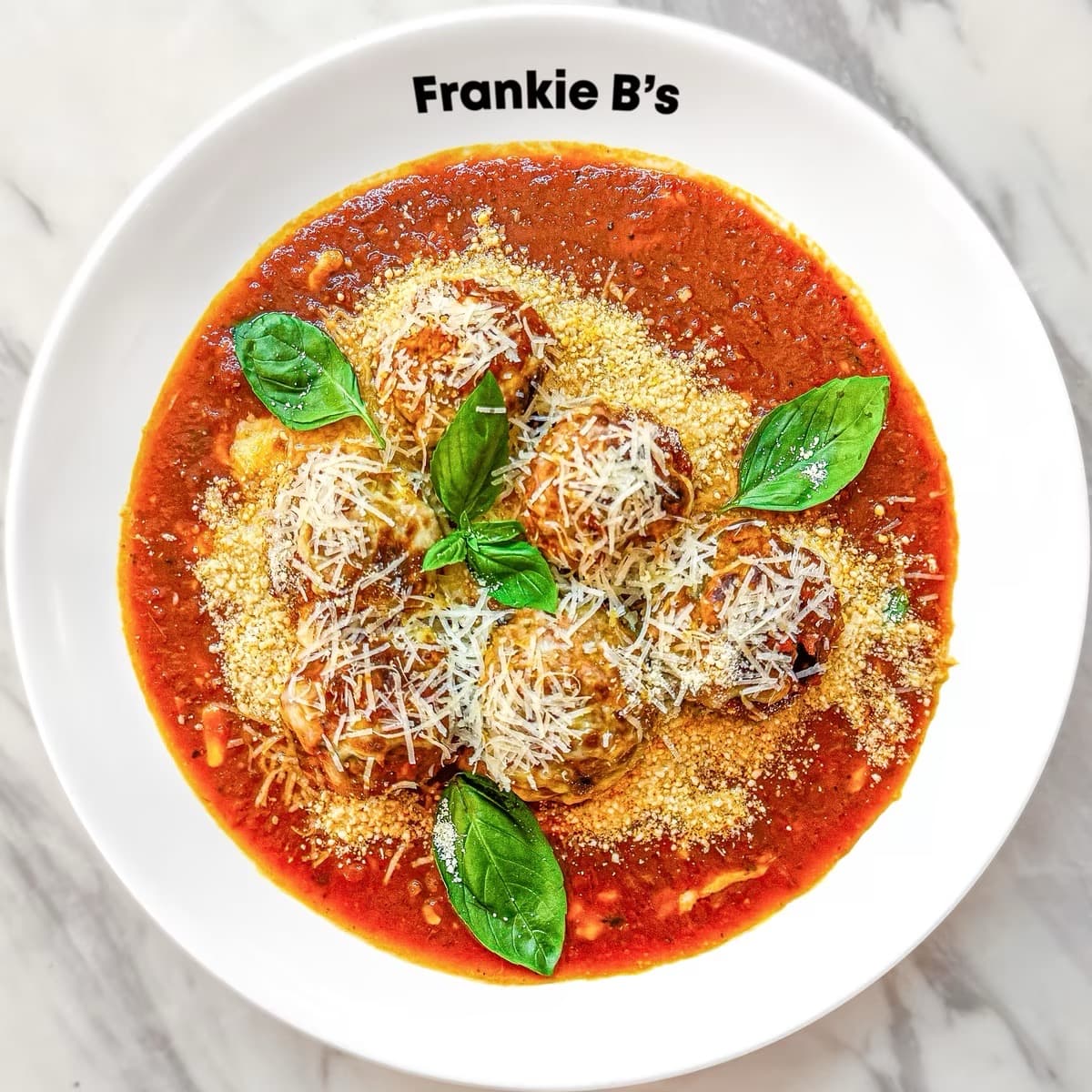 Delicious mozzarella meatballs served with rich sauce and garnishes.